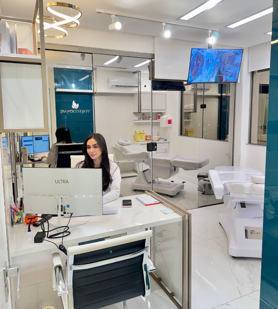 Consultório de clínica de estética em São José SC com funcionária no computador